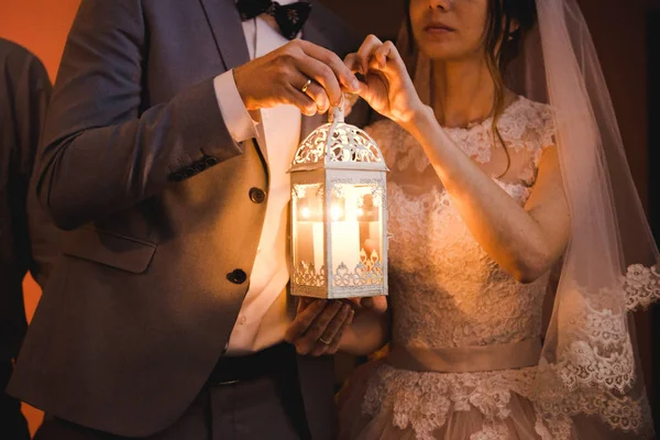 Braut und Bräutigam halten eine Hochzeitskerze, das Ende der Hochzeit und die Gründung einer neuen Familie. Traditionen und Bräuche. Ukrainische Trauung. — Stockfoto