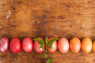 Ahşap bir arka plan üzerinde Paskalya yumurtaları. Mutlu paskalyalar. Parlak çok renkli parlak paskalya yumurtaları. Copyspace. Paskalya yumurtaları ile arka plan. Metin için yer