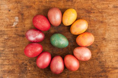 Ahşap bir arka plan üzerinde Paskalya yumurtaları. Mutlu paskalyalar. Parlak çok renkli parlak paskalya yumurtaları. Copyspace. Çok renkli yumurtalar daire içinde yatıyor. Metin için yer