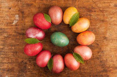 Ahşap bir arka plan üzerinde Paskalya yumurtaları. Mutlu paskalyalar. Parlak çok renkli parlak paskalya yumurtaları. Copyspace. Çok renkli yumurtalar daire içinde yatıyor. Metin için yer