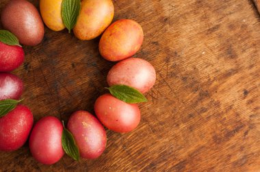 Ahşap bir arka plan üzerinde Paskalya yumurtaları. Mutlu paskalyalar. Parlak çok renkli parlak paskalya yumurtaları. Copyspace. Çok renkli yumurtalar daire içinde yatıyor. Metin için yer