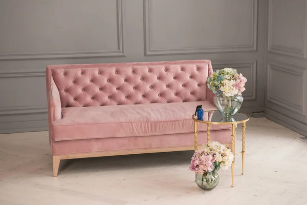 Beautiful pink sofa. Living room interior. Interior with vintage furniture elements.