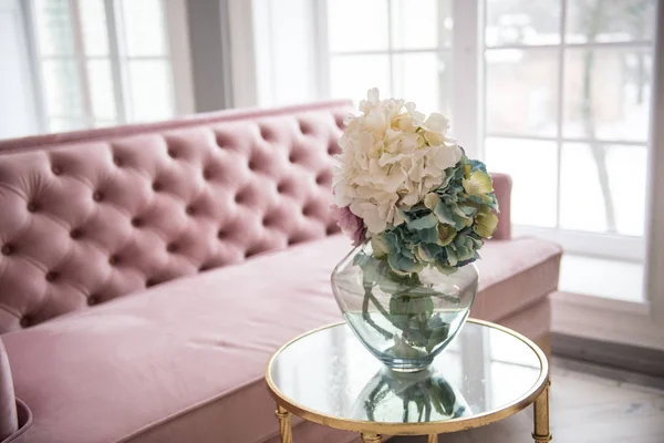 Beautiful pink sofa. Living room interior. Interior with vintage furniture elements.