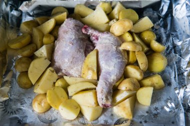 Patates ile çiğ tavuk bacağı pişirilmeye hazır. Pişirme için formda çiğ patates ile çiğ tavuk, pişirilmeye hazır.