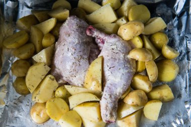 Patates ile çiğ tavuk bacağı pişirilmeye hazır. Pişirme için formda çiğ patates ile çiğ tavuk, pişirilmeye hazır.