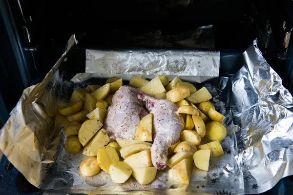 Raw chicken leg with potatoes ready to be cooked. Raw chicken with raw potatoes in the form for baking, ready to be cooked.