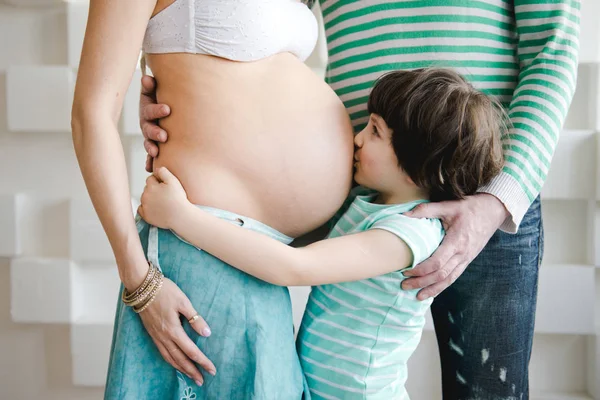 Portrait d'un petit garçon heureux embrassant le ventre enceinte de sa mère. Nouveau concept de vie. Joyeux deuxième femme enceinte. mignon enfant câlin ventre enceinte mère . — Photo