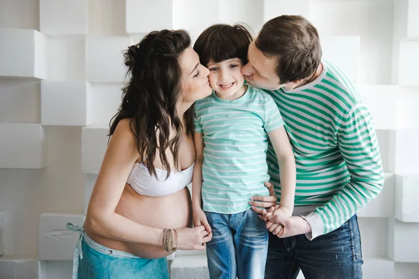 Une famille heureuse attend un deuxième enfant. Les derniers mois de grossesse. Femme enceinte avec mari et petit garçon. Deuxième grossesse, concept de maternité . — Photo