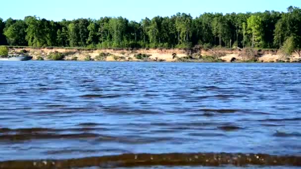 Le vent entraîne les vagues sur la rivière, le lac, les vagues sur une plage de sable fin .