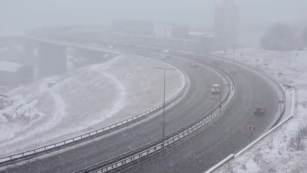 Carros dirigindo na estrada nevada no inverno, tráfego na estrada na queda de neve, nevasca — Vídeo de Stock