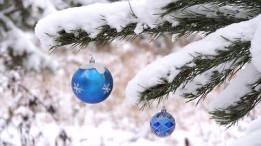 Ormanda kar yağışı kışın Noel oyuncak ile şube rüzgarda sways.