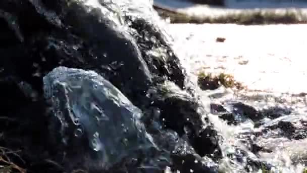 Горный водопад, ручей, река. Вода брызгает на камни при солнечном свете — стоковое видео