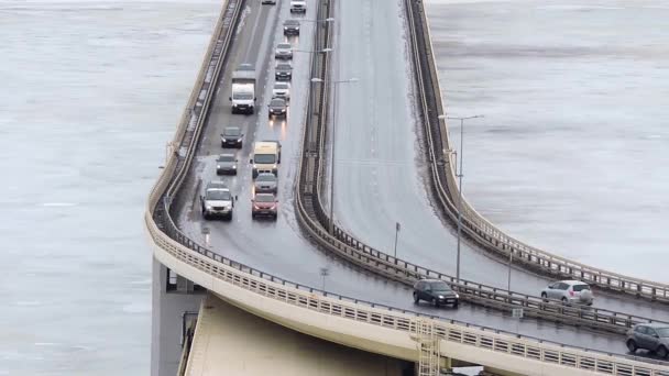 Автомобили едут по снежной дороге зимой, движение по мосту, шоссе — стоковое видео