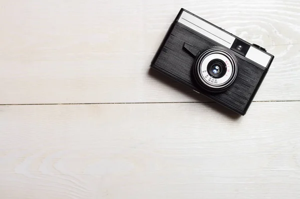 Classic film camera on wooden background.