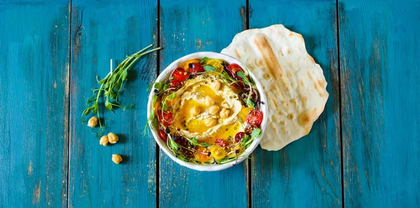 Hummus con aceite de oliva, brotes y tomates — Foto de Stock