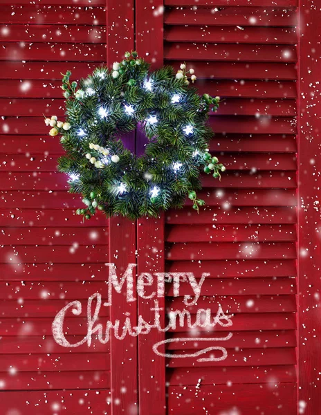 Рождественский венок на красных деревянных ставнях . Лицензионные Стоковые Фото