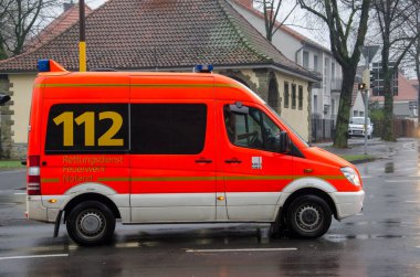 Soest, Almanya - 20 Aralık 2017: Bir sokakta Alman ambulans servisi araba kullanıyor. Aranan Avrupa Acil durum numarası 112 olduğunu ücretsiz olarak yangın ve acil yardım için kullanılır.