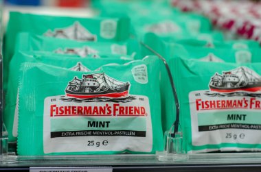 Soest, Germany - January 3, 2018: Fishermen's Friend lozenge for sale in the supermarket. Fisherman's Friend is a brand of strong menthol lozenges produced by the Lofthouse. clipart