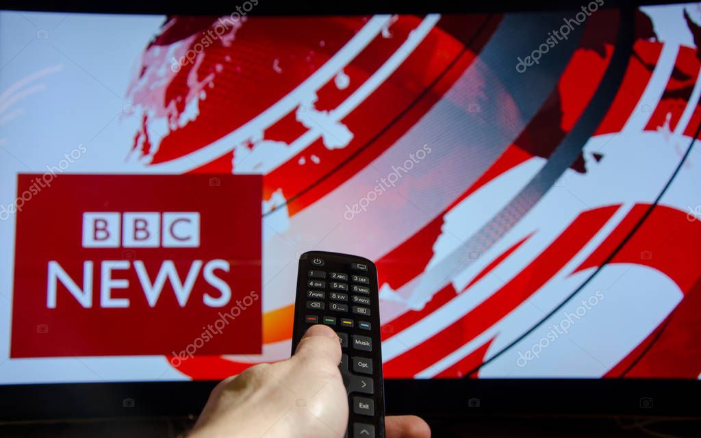Soest, Germany - January 14, 2018: Man watching BBC News on TV. BBC News is an operational business division of the British Broadcasting Corporation (BBC).
