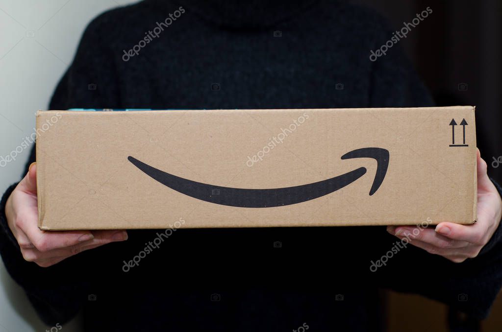 Soest, Germany - December 12, 2018: Woman receiving Amazon Prime package.