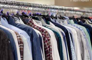 Mağazadaki askılarda asılı giysiler.