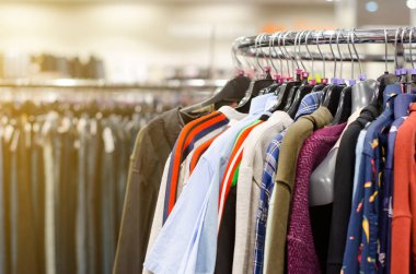 Mağazadaki askılarda asılı giysiler.