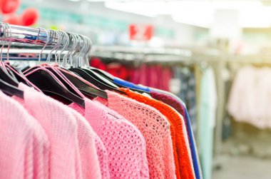 Mağazadaki askılarda asılı giysiler.