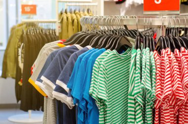 Mağazadaki askılarda asılı giysiler.
