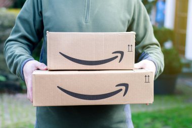 Soest, Germany - January 14, 2019:  Man delivers Amazon Prime package. clipart