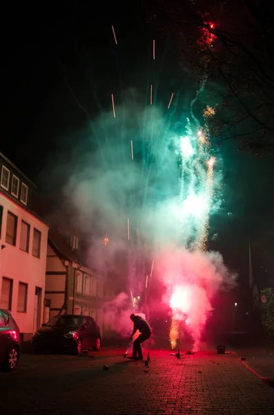 People launch fireworks on the street.