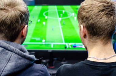 Çocuklar bir futbol video oyunu oynuyorlar..