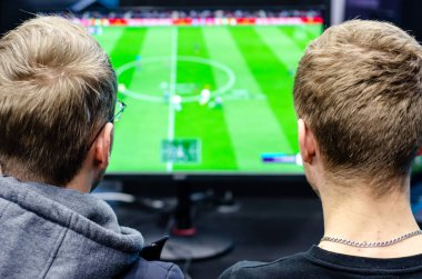 Çocuklar bir futbol video oyunu oynuyorlar..