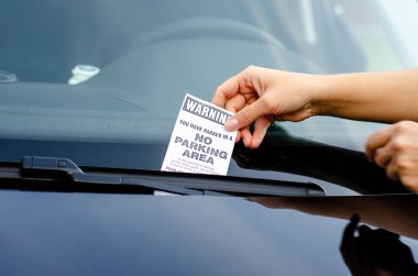 Close-up Of A Woman Taking Parking Ticket On Car's Windshield clipart