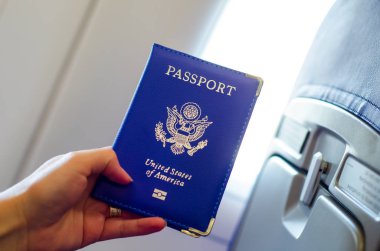 Uçak kabiniçinde el tutarak ABD pasaportu.