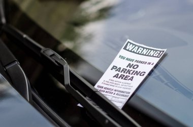Close-up of parking ticket on car's windshield clipart