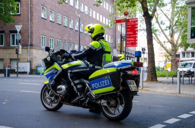 Dortmund, Almanya - 2 Ağustos 2019: Sokaklarda devriye gezen motosikletli polis. Motosikletli polisler sokakta.