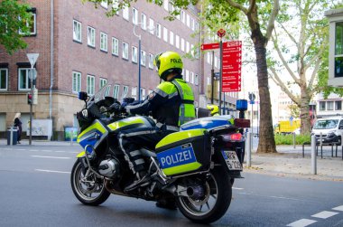 Dortmund, Almanya - 2 Ağustos 2019: Sokaklarda devriye gezen motosikletli polis. Motosikletli polisler sokakta.