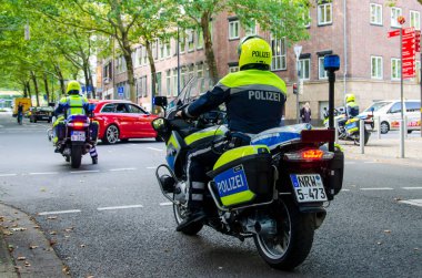 Dortmund, Almanya - 2 Ağustos 2019: Sokaklarda devriye gezen motosikletli polis. Motosikletli polisler sokakta.