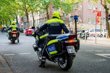 Dortmund, Almanya - 2 Ağustos 2019: Sokaklarda devriye gezen motosikletli polis. Motosikletli polisler sokakta.