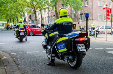 Dortmund, Almanya - 2 Ağustos 2019: Sokaklarda devriye gezen motosikletli polis. Motosikletli polisler sokakta.