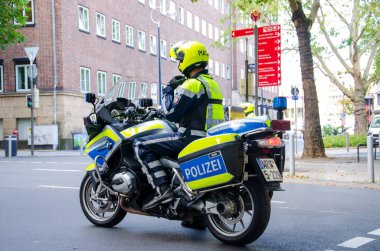 Dortmund, Almanya - 2 Ağustos 2019: Sokaklarda devriye gezen motosikletli polis. Motosikletli polisler sokakta.