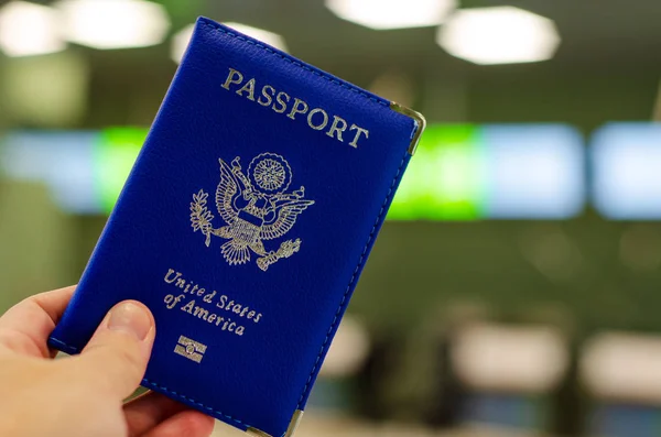 Hand innehav amerikanskt pass på flygplatsen — Stockfoto