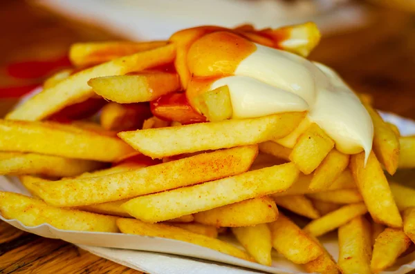 Close-up of french fries with ketchup and mayo.