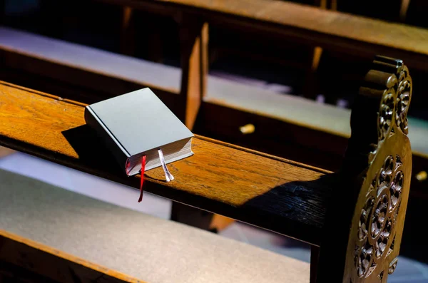 Biblia leży na Kneelers w kościele. — Zdjęcie stockowe