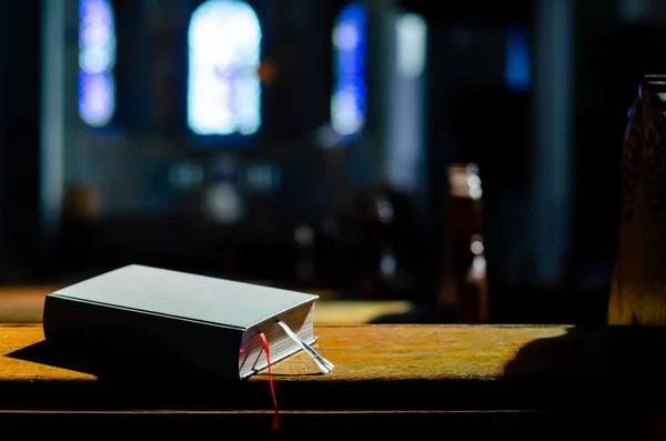 Biblia leży na Kneelers w kościele. — Zdjęcie stockowe