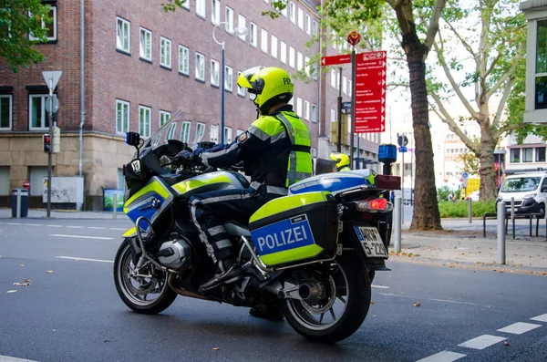 Dortmund, Niemcy-2 sierpnia 2019: policjanta na motocyklu patrolowania ulic. Policemans motocykl na ulicy. — Zdjęcie stockowe