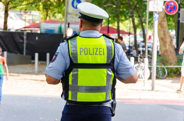 Дортмунд, Німеччина-2 серпня 2019: поліцейський патрулював і тримає замовлення на громадському заході. — стокове фото