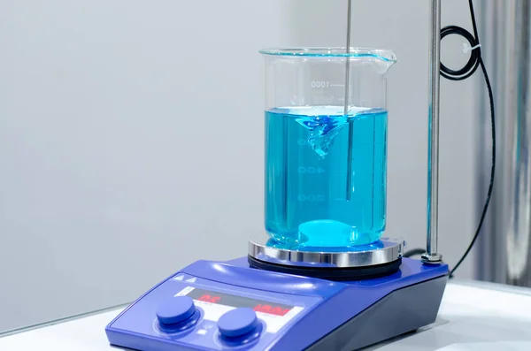 A magnetic stirrer or magnetic mixer is a laboratory device that employs a rotating magnetic field to cause a stir bar immersed in a liquid to spin very quickly, thus stirring it. — Stock Photo, Image