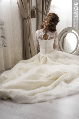 Genç güzel gelin aynanın önünde oturur. Gelin sabah. Düğün hazırlıkları. 