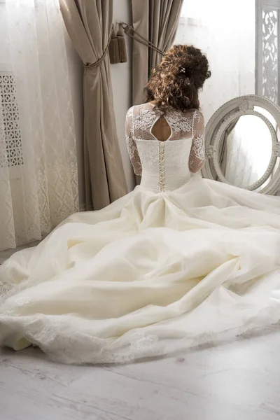 Genç güzel gelin aynanın önünde oturur. Gelin sabah. Düğün hazırlıkları. 